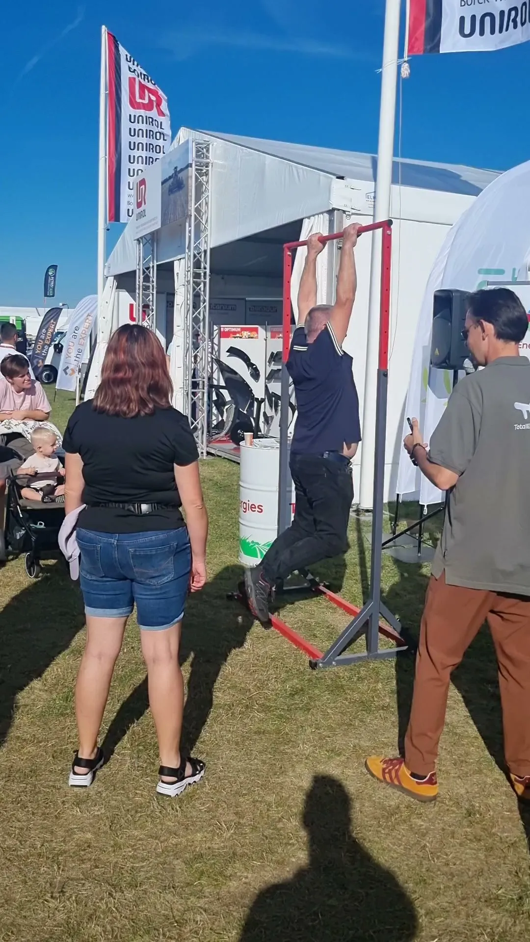 Konkurs podciągania na drążku na stoisku TotalEnergies na Agro Show, konferansjer z mikrofonem