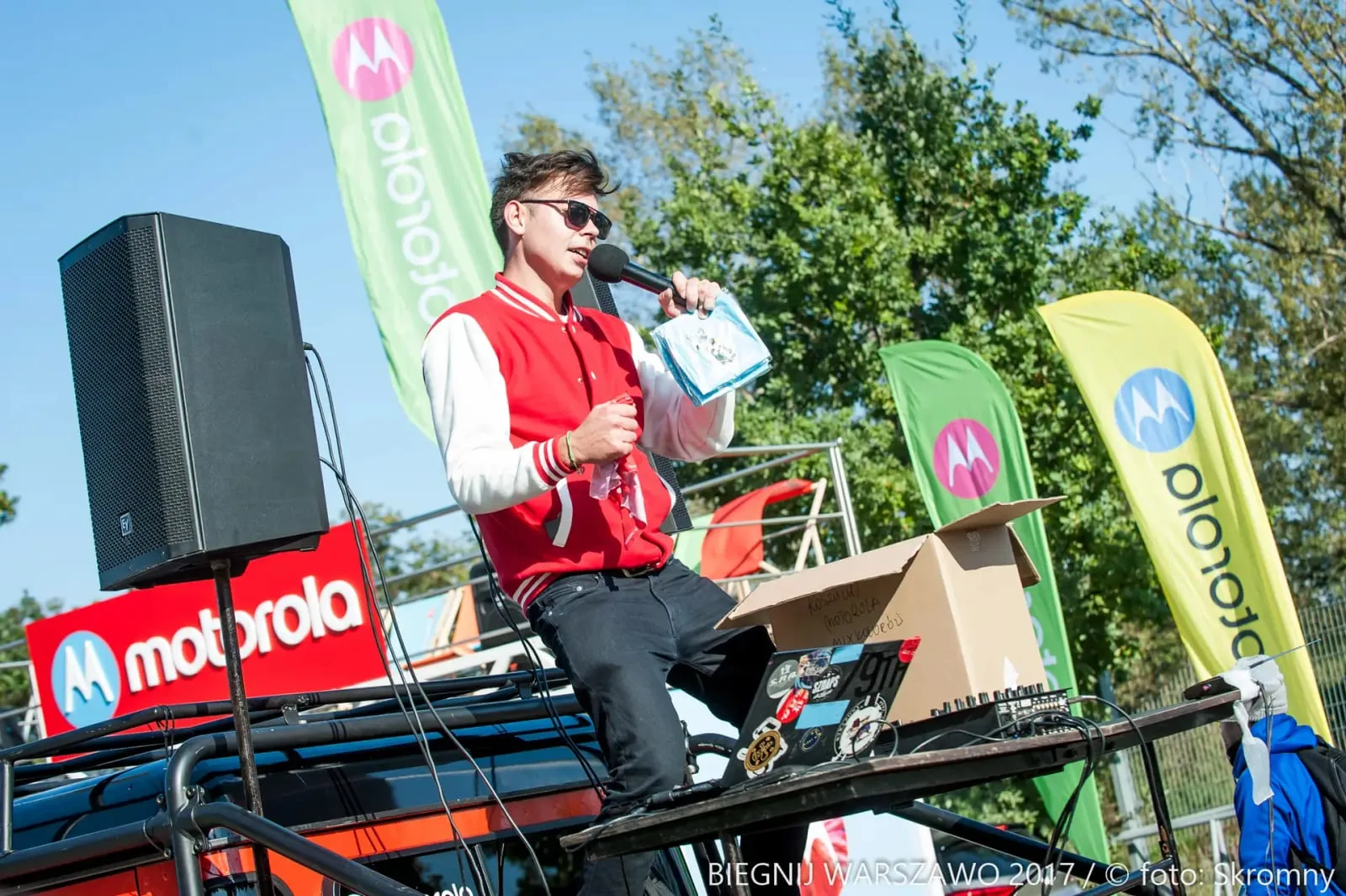 Prowadzący z mikrofonem na scenie strefy Motorola podczas Biegnij Warszawo