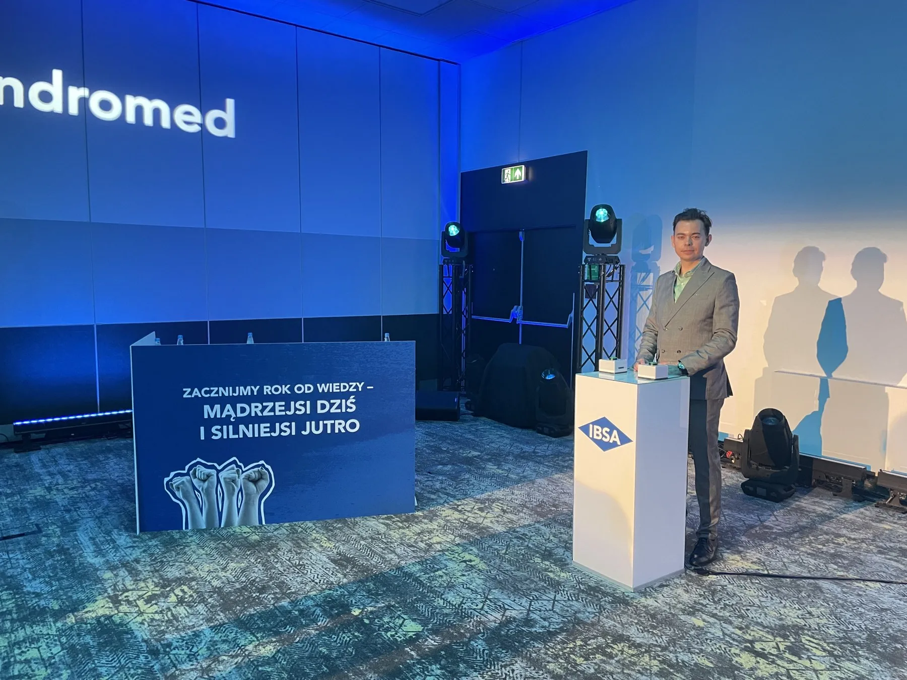 Prowadzący Szymon Alaba przy pulpicie IBSA na scenie konferencji z hasłem Zacznijmy rok od wiedzy