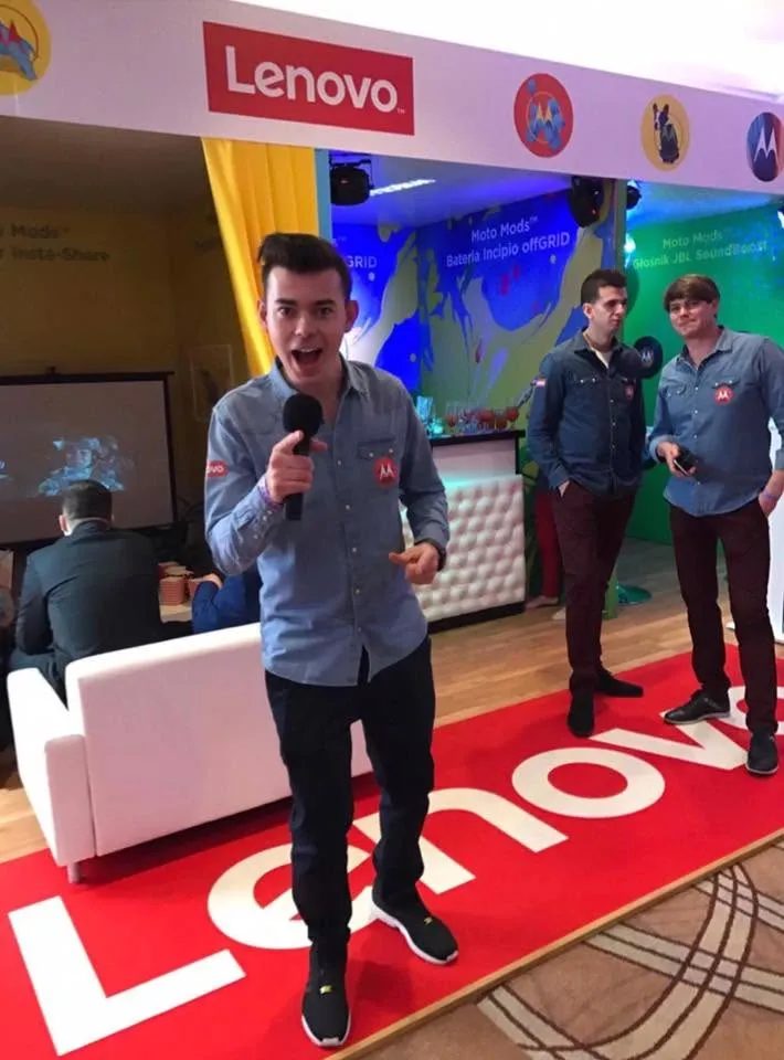 Szymon Alaba z mikrofonem na czerwonym dywanie w strefie Lenovo podczas X Konferencji Sprzedaży Play