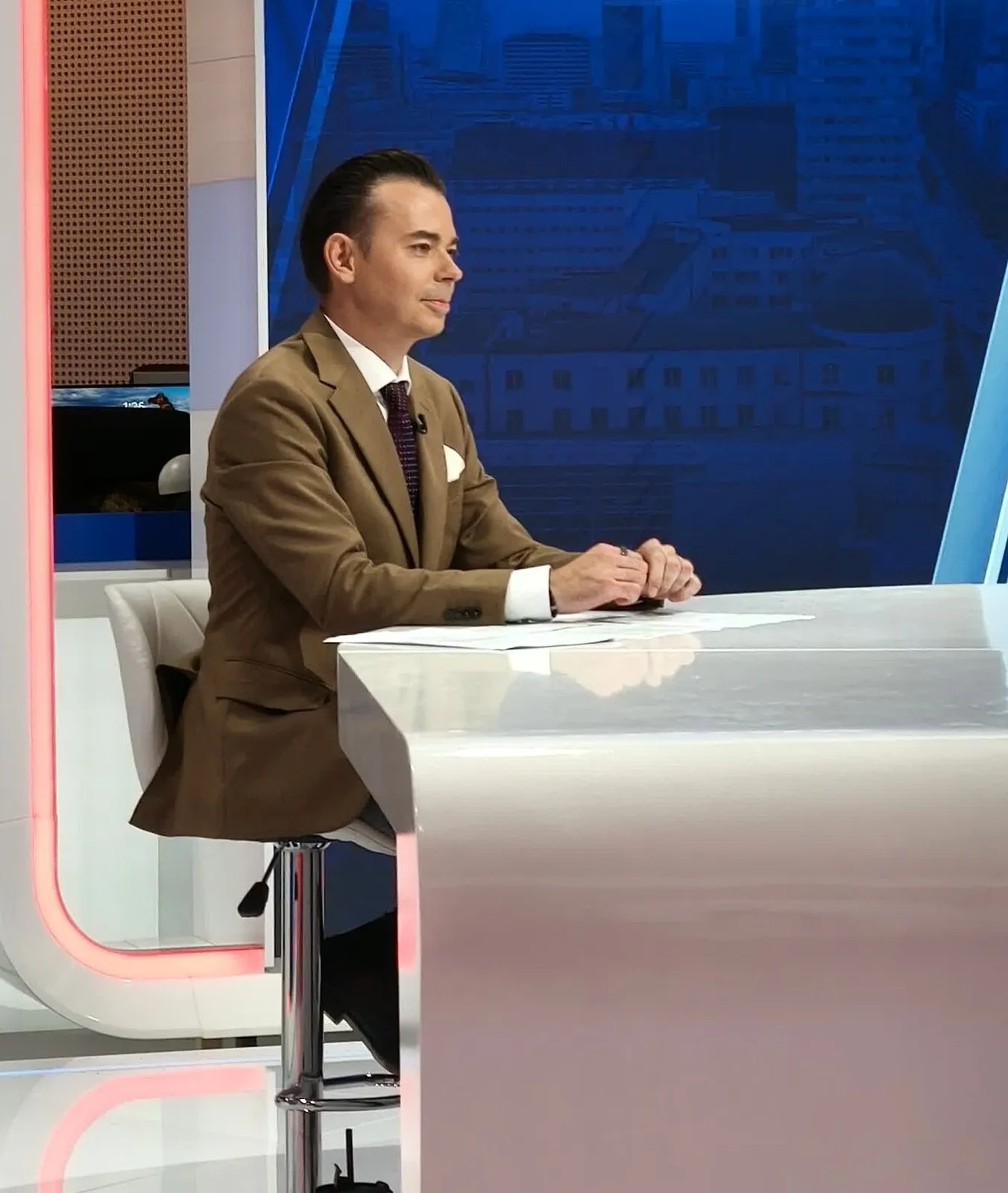 Szymon Alaba przy stole prezenterskim w studiu Dziennika Newsmax Polska TV