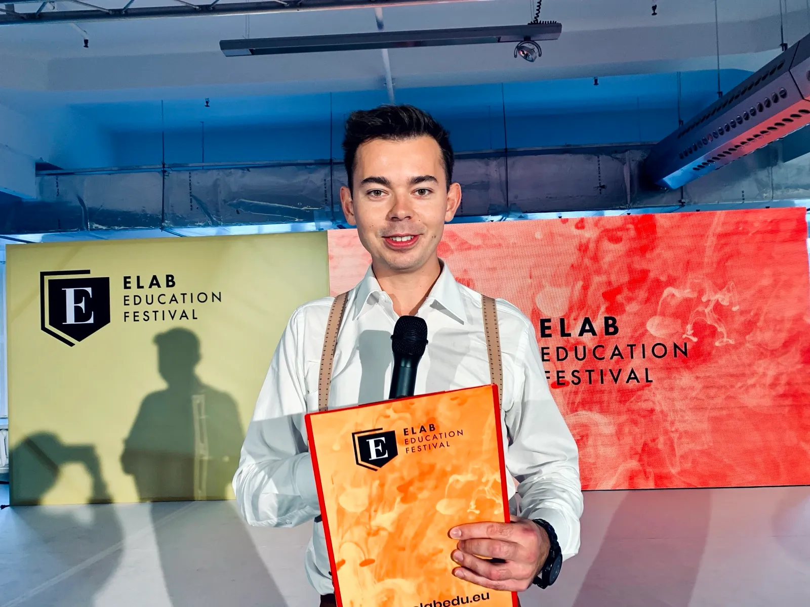 Szymon Alaba z mikrofonem i dyplomem na ELAB Education Festival