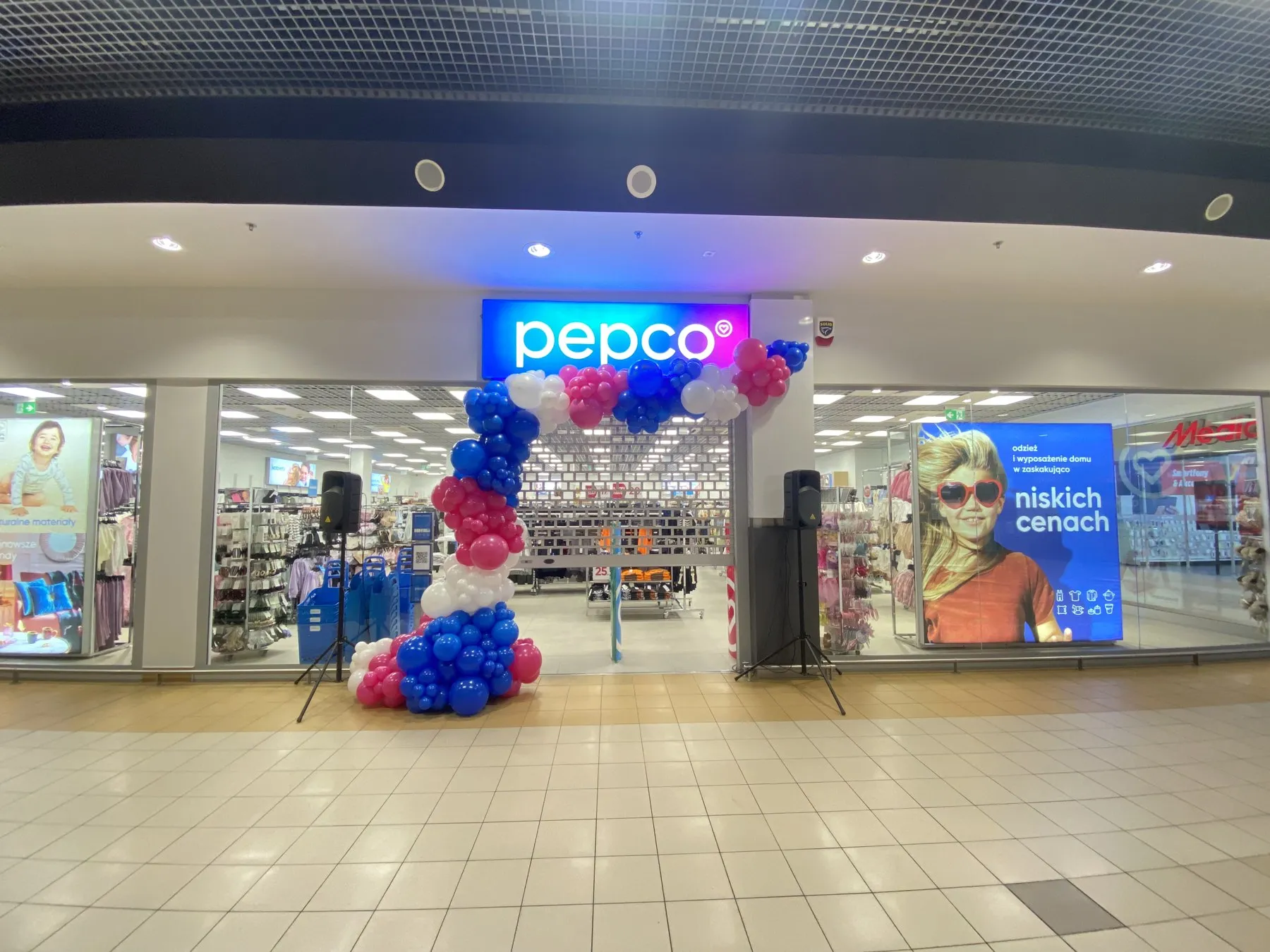 Otwarcie sklepu Pepco w galerii handlowej: balonowa brama i dwie kolumny nagłośnienia konferansjera