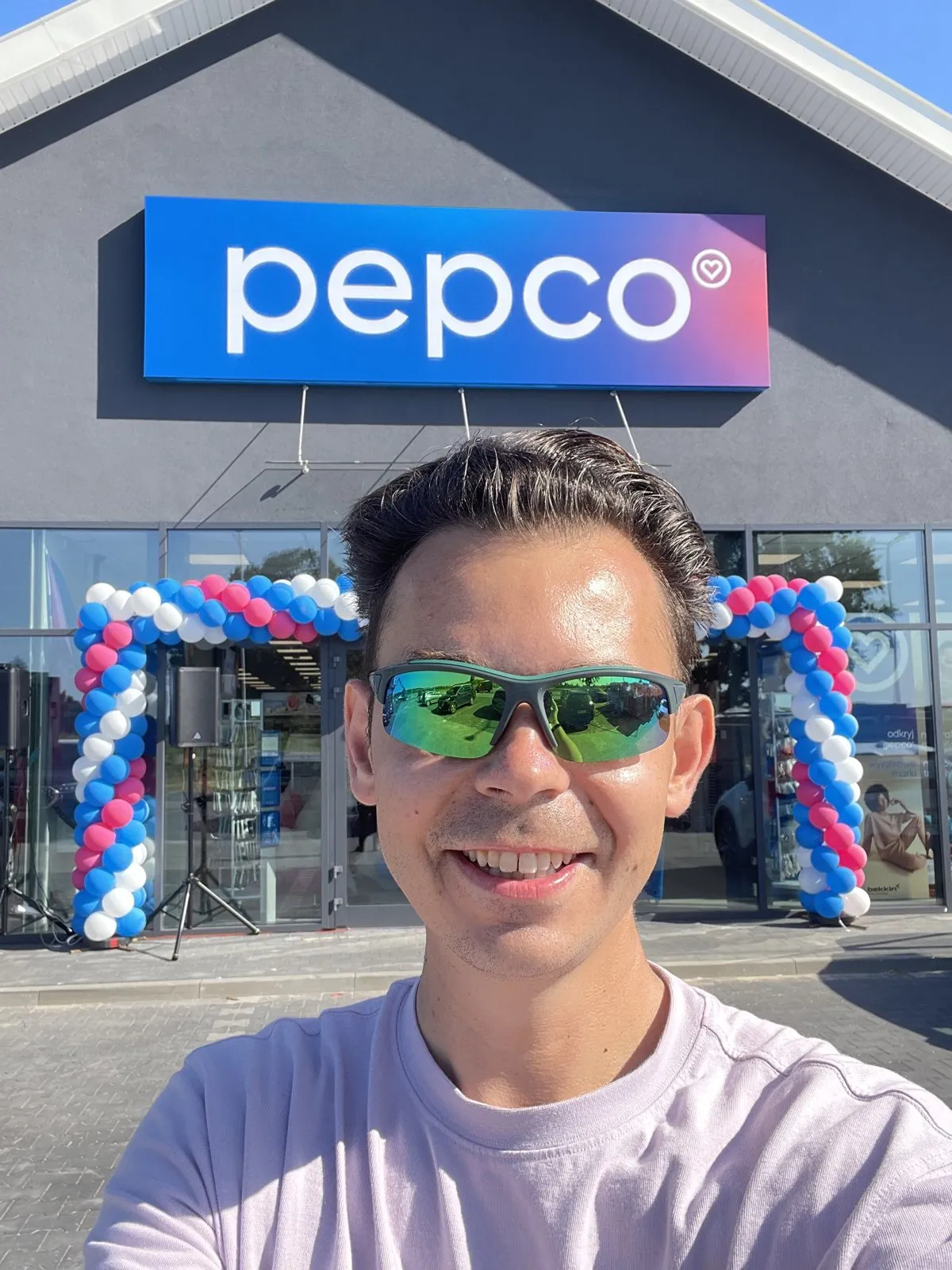 Szymon Alaba przed wejściem do nowego sklepu Pepco z balonową bramą w dniu otwarcia