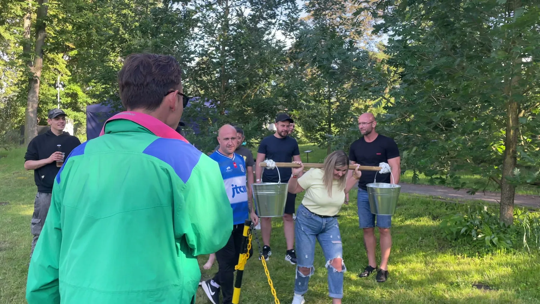 Konferansjer z mikrofonem prowadzi konkurencje drużynowe na trawie podczas pikniku aluplast