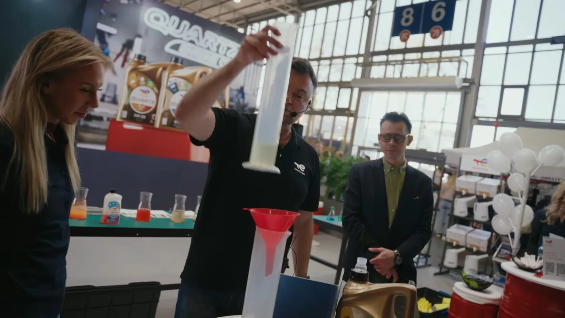 Pokaz w Laboratorium Quartz na stoisku TotalEnergies podczas Poznań Motor Show 2026, obok konferansjer