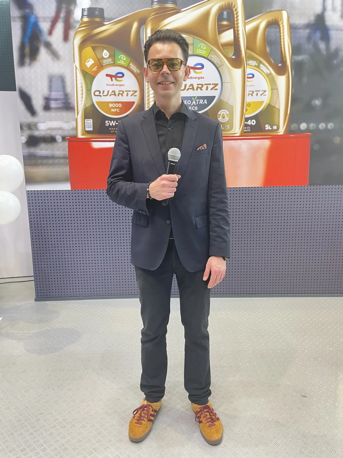 Prowadzący z mikrofonem na stoisku TotalEnergies, Poznań Motor Show 2026