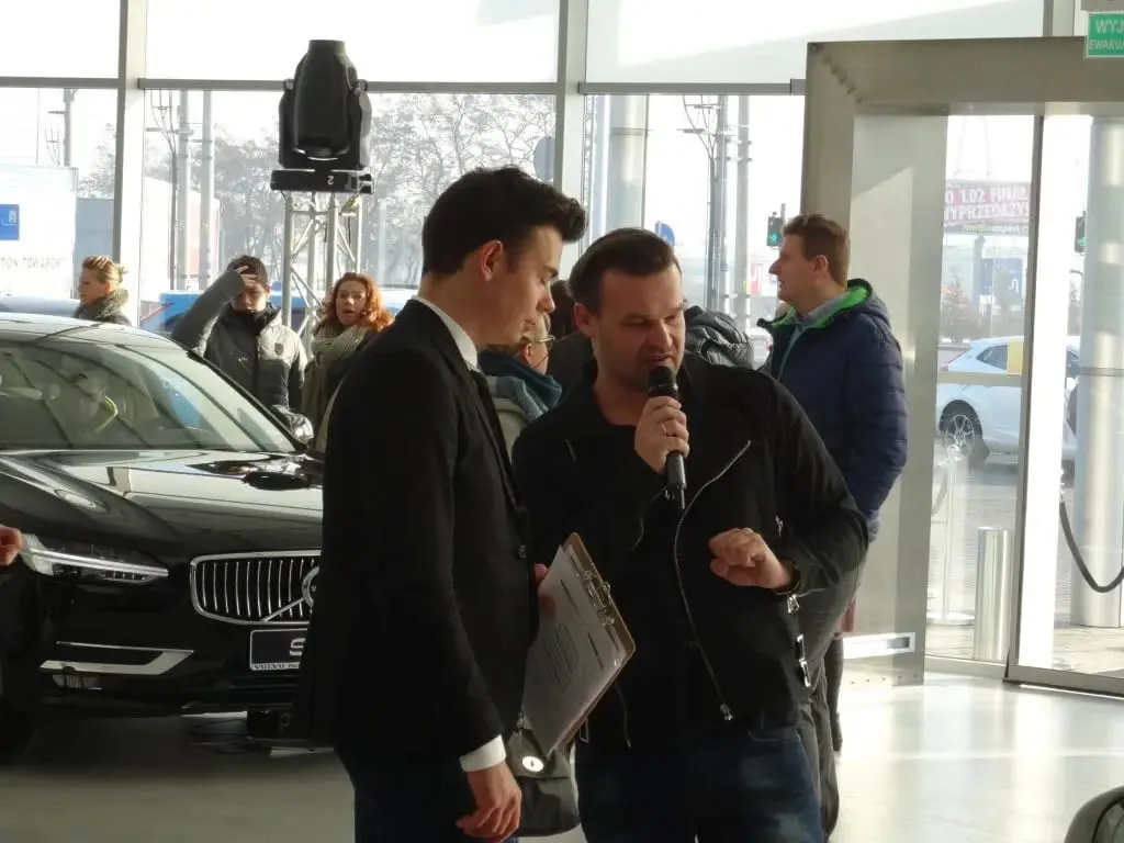 Prowadzący z mikrofonem w salonie Volvo w Płocku podczas otwarcia